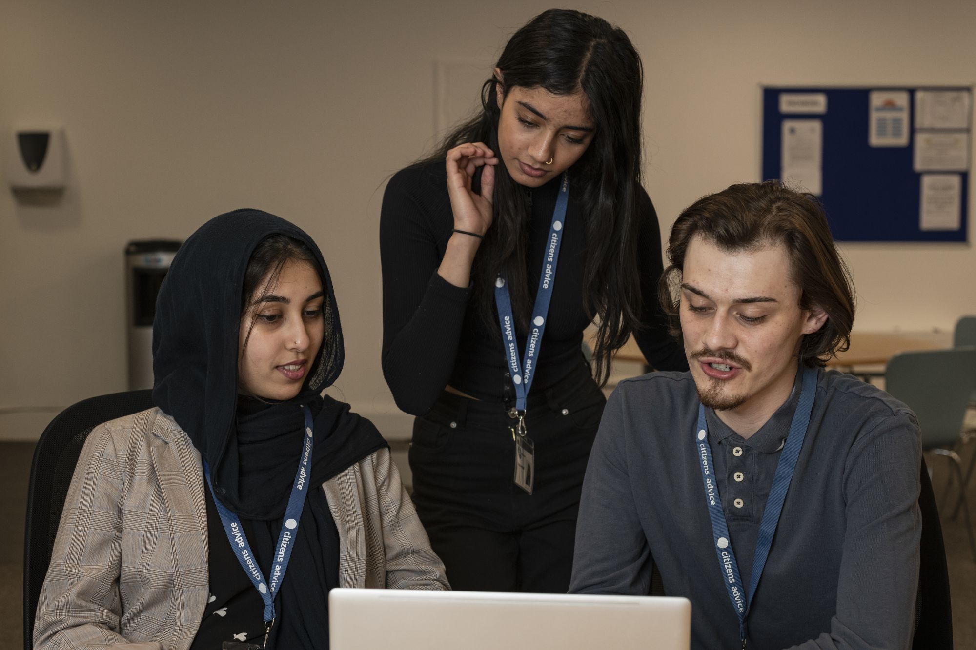 serious adult volunteers working on laptop 8678